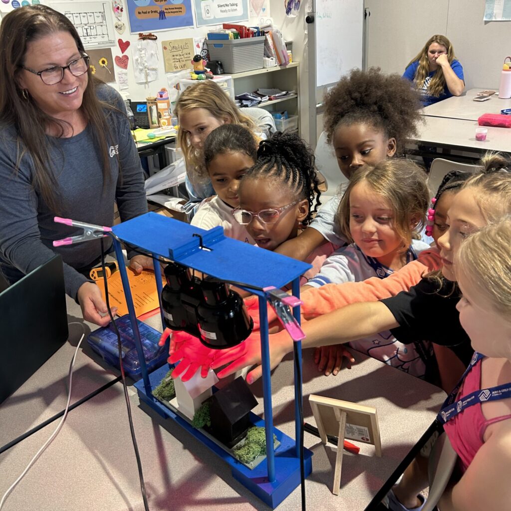 Photo of students experimenting with different colored materials under a heat lamp